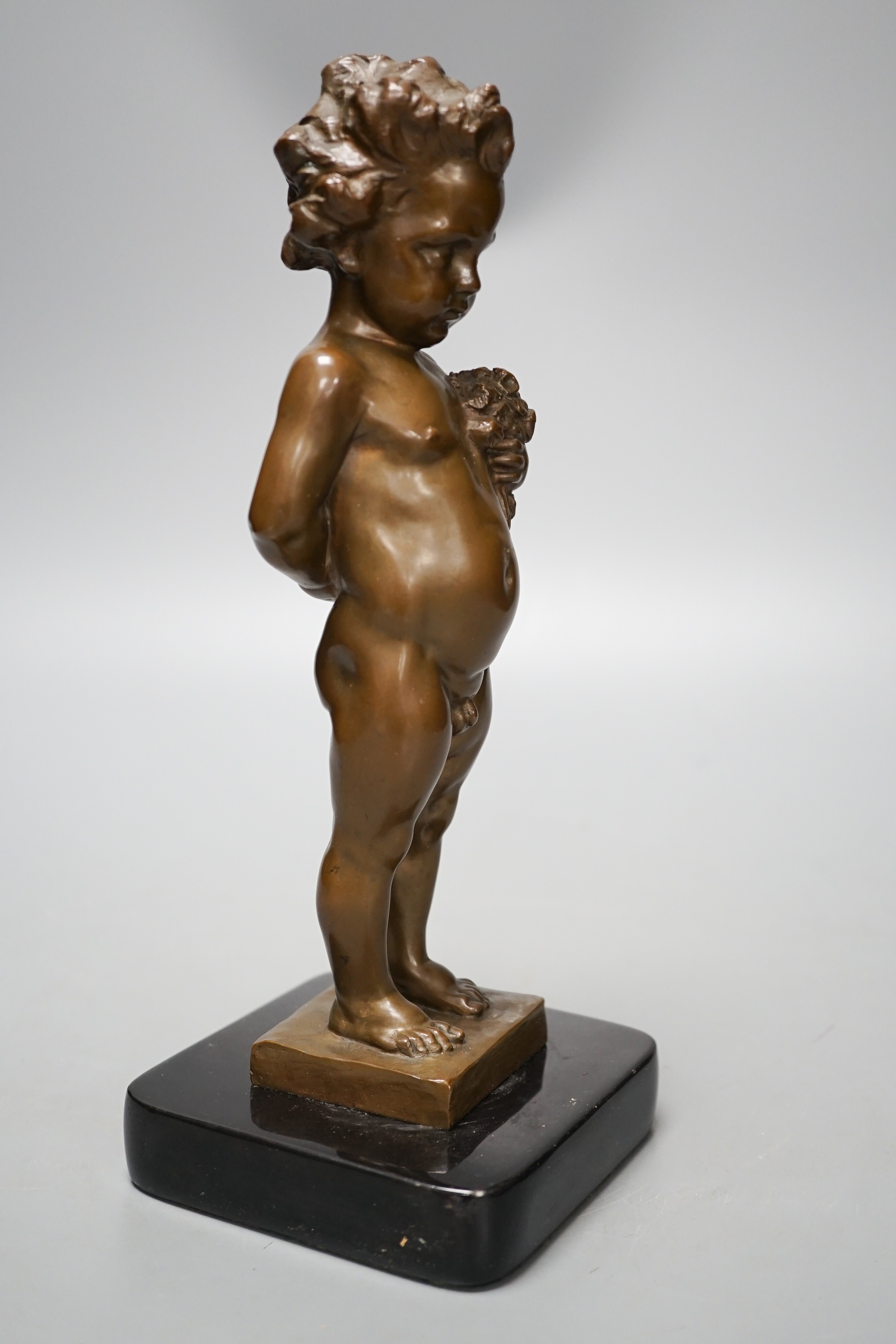 A bronze of a putto holding flowers, signed ‘M.Müller’ 25cm